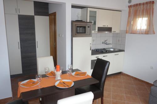 comedor con mesa y cocina en Apartments SoldInn, en Privlaka