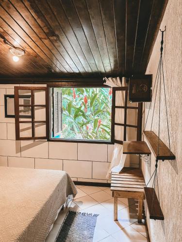 a bedroom with a bed and a window at Balaio Hostel Ilha Grande in Abraão