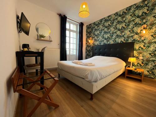 a bedroom with a bed and a wall of flowers at Le Cheval Blanc in Jargeau