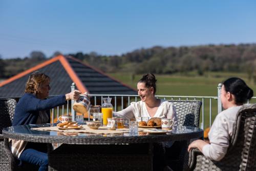 un grupo de personas sentadas alrededor de una mesa en una cubierta en Dulrush Lodge Guest House, Restaurant and Self-Catering, en Belleek