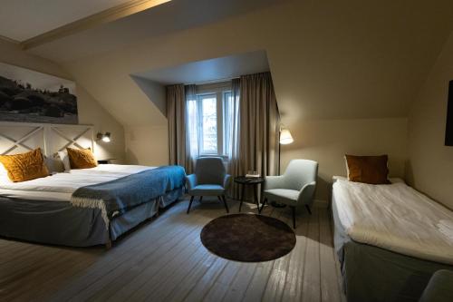 a hotel room with two beds and a window at Åtellet Hotell in Norrtälje