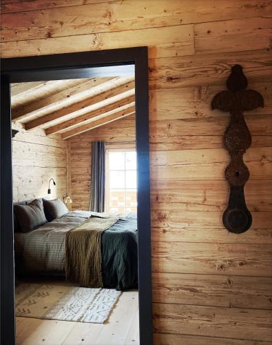 a bedroom with a bed and a wooden wall at Stefan Glowacz CHALET mit traumhaftem Bergblick in Grainau