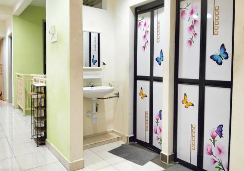 baño con lavabo y mariposas en la pared en JB Austin Perdana Homestay@Simple Comfy For 11pax en Johor Bahru