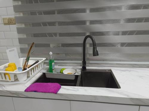 a kitchen sink with a purple rag and a sink at LUXURY Modern House Kubang Kerian UNIFI 4 Bedrooms in Kota Bharu