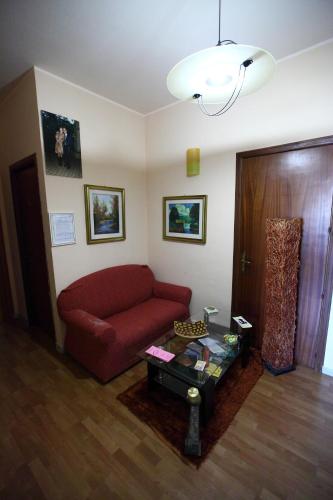 a living room with a red couch and a table at Casa Albergo La Terza Stella in Agira