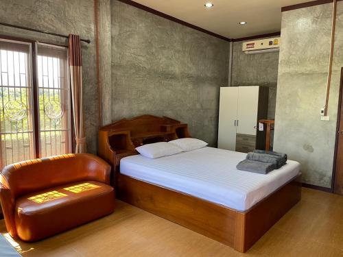 una camera con letto e sedia di Yaowarate Sport Club and Resort ไร่เยาวเรศ a Ban Mae Ho Phra