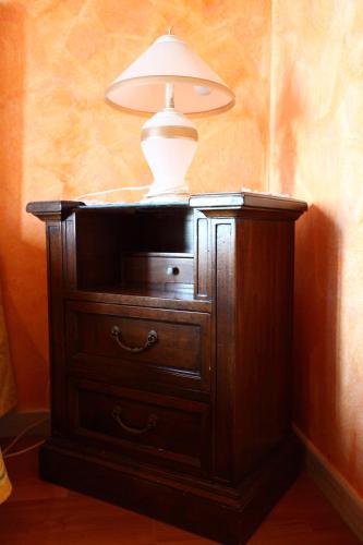 a lamp sitting on top of a wooden dresser at Casa Albergo La Terza Stella in Agira