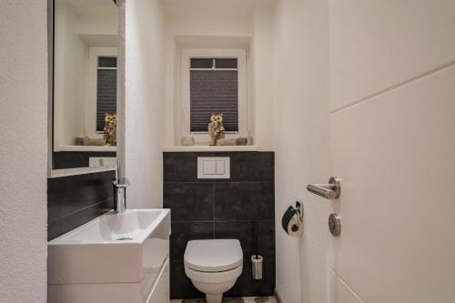 a bathroom with a white toilet and a sink at Haus Bambi in Achenkirch