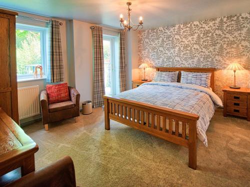 a bedroom with a large bed and a chair at Vyrnwy Lakeside - Bala Lake in Bala