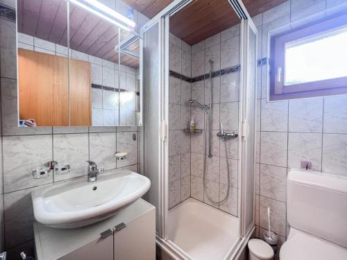 a bathroom with a sink and a shower and a toilet at Chalet Dennda Nr 27 in Rosswald
