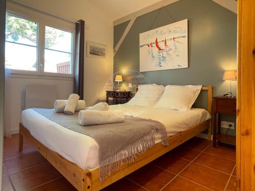 a bedroom with a large bed with white sheets at Jolie Maison cœur de Capbreton in Capbreton
