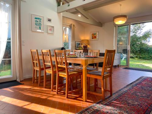 une salle à manger avec une table et des chaises en bois dans l'établissement Jolie Maison cœur de Capbreton, à Capbreton