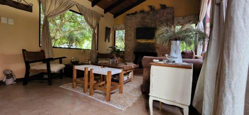 sala de estar con sofá y mesa en La Escondida, en Villa Serrana