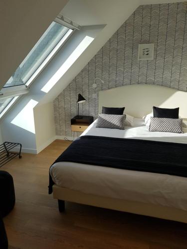 a bedroom with a large bed in a attic at Les Chants d'Ailes - Hôtel Face Mer in La Turballe