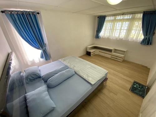 um quarto com uma cama grande e cortinas azuis em Villa Berastagi Indah A17 - TEBU MANIS em Berastagi