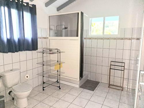 a white bathroom with a toilet and a shower at La Familiale in Sainte-Rose