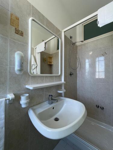 a bathroom with a sink and a mirror and a tub at Albergo Désirée in Alba Adriatica