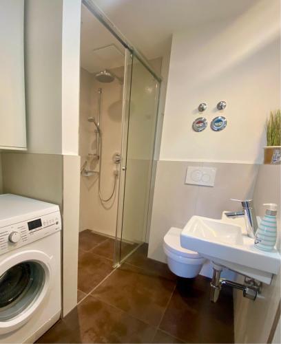 ein Badezimmer mit Waschmaschine und Waschbecken in der Unterkunft 3000 - Grömitz in Grömitz