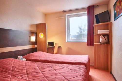 a hotel room with a bed and a window at Premiere Classe Le Mans Ouest Universite in Le Mans