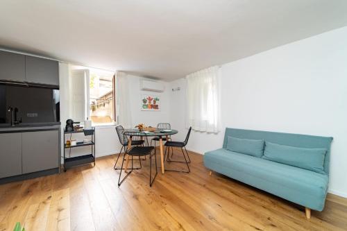 een woonkamer met een blauwe bank en een tafel bij Casa Gagini in Palermo