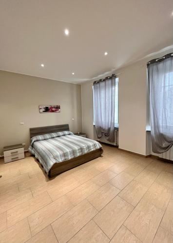 a bedroom with a large bed and two windows at Alloggio Nina 2 in Biella