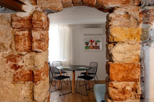 een boog in een kamer met een tafel en stoelen bij Casa Gagini in Palermo