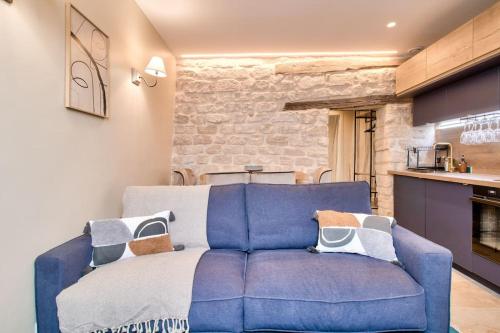 - un canapé bleu dans un salon avec une cuisine dans l'établissement Cozy apartement heart historic Paris, à Paris