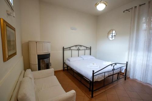 a bedroom with a bed and a couch at La Dimora delle Emozioni - Il Fascino del Centro Storico e L'adrenalina dell'Autodromo in Imola
