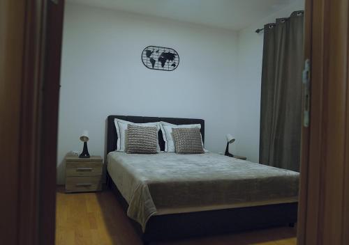 a bedroom with a bed with a clock on the wall at Aster Apartments in Belgrade