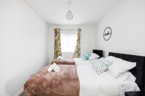 a bedroom with two beds and a window at Newly refurbished charming 3-Bed House in Barking in Barking
