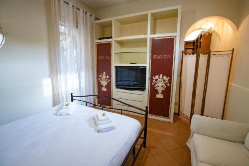 a bedroom with a bed and a tv and a couch at La Dimora delle Emozioni - Il Fascino del Centro Storico e L'adrenalina dell'Autodromo in Imola