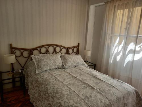 Schlafzimmer mit einem Bett und einem Fenster in der Unterkunft Centro in Buenos Aires