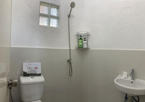 bagno bianco con servizi igienici e lavandino di REMMs PLACE Aircondition unit A a Kay Riapay