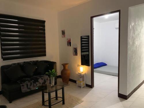 un soggiorno con divano nero e specchio di REMMs PLACE Aircondition unit A a Kay Riapay