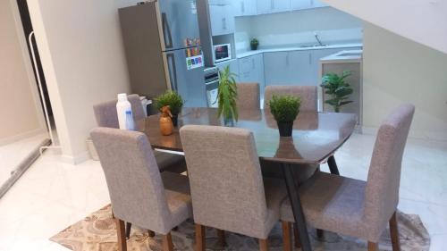 a dining room table with chairs and a kitchen at فيلا الكادي in Al Hada
