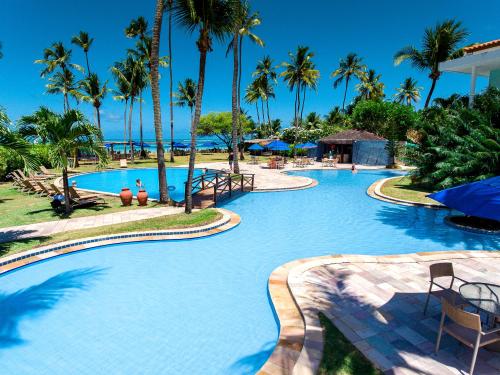 a swimming pool at a resort with palm trees at Baía Branca Beach Resort in Tamandaré