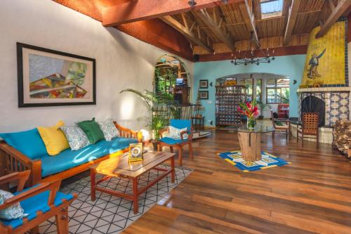 a living room with a blue couch and wooden floors at Finca Rosa Blanca Coffee Farm and Inn in Heredia