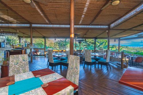 a restaurant with tables and chairs and a view at Finca Rosa Blanca Coffee Farm and Inn in Heredia