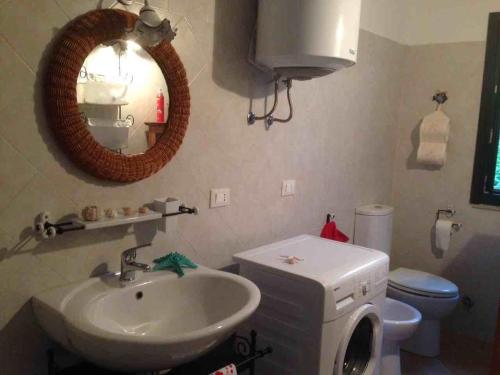 a bathroom with a sink and a toilet and a mirror at Holiday in Sardinia in Santa Maria