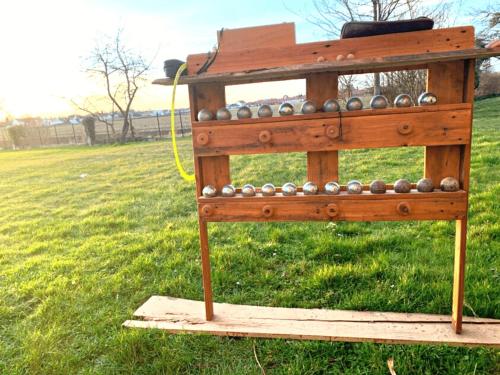 une structure en bois avec des billes dans un champ dans l'établissement Logements calmes avec piscine, jardin et parking, à Buchères