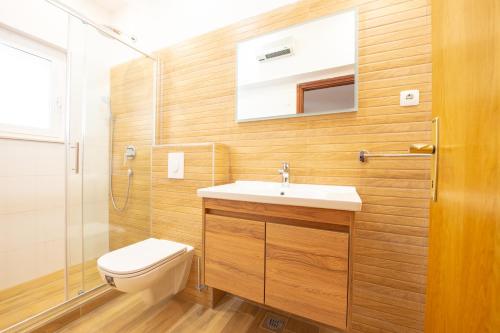 a bathroom with a toilet and a sink and a shower at Apartments Facini in Košljun