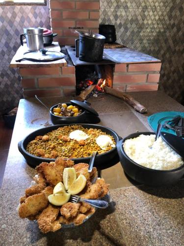 a table with several dishes of food on a counter at Recanto das Aves in Botumirim