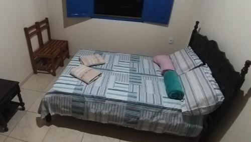 a large bed in a room with a chair at Recanto das Aves in Botumirim
