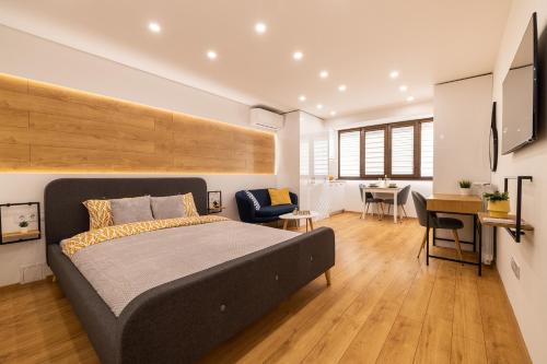 a bedroom with a large bed and a desk in a room at Luxury Studio Living: High-End Amenities and Great Location in Sofia