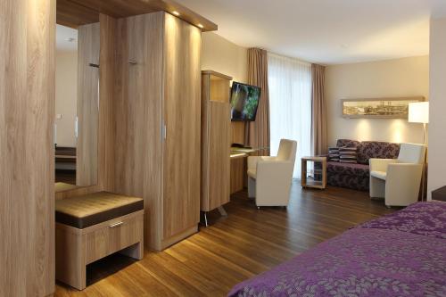 a hotel room with a bed and a living room at Hotel Simonshof in Wolfsburg
