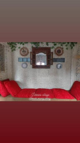 a red couch with a mirror on a wall at Villa puncak bogor Imah mang iding in Bogor