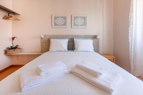Una cama blanca con dos toallas blancas. en Charming 120m² in Historic Center, en Lamego