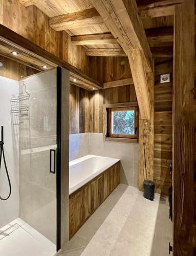 une salle de bain avec baignoire et douche dans l'établissement Chalet de luxe sur les pistes - 5 chambres, à Combloux