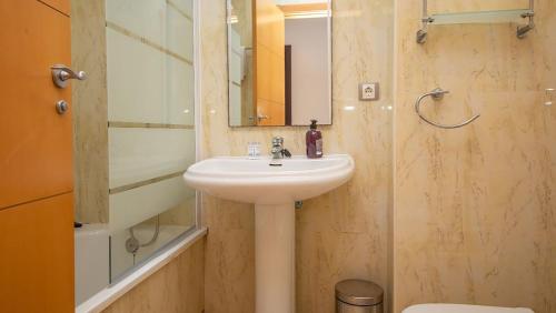 a bathroom with a sink and a mirror and a toilet at Residencial Duquesa Ground Floor Apartment in San Luis de Sabinillas