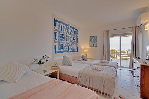 ヴィラモウラにあるAl charb vilamoura Apartmentのベッド2台とバルコニーが備わるホテルルームです。